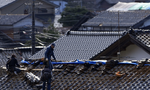 4일 일본 이시카와현 노토반도 나나오시에서 사람들이 강진의 여파로 손상된 주택의 지붕을 수리하고 있다. [사진=연합뉴스]