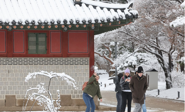 22일 오전 밤사이 내린 눈이 쌓인 서울 덕수궁에서 외국인 관광객들이 눈싸움하고 있다. [사진=연합뉴스]